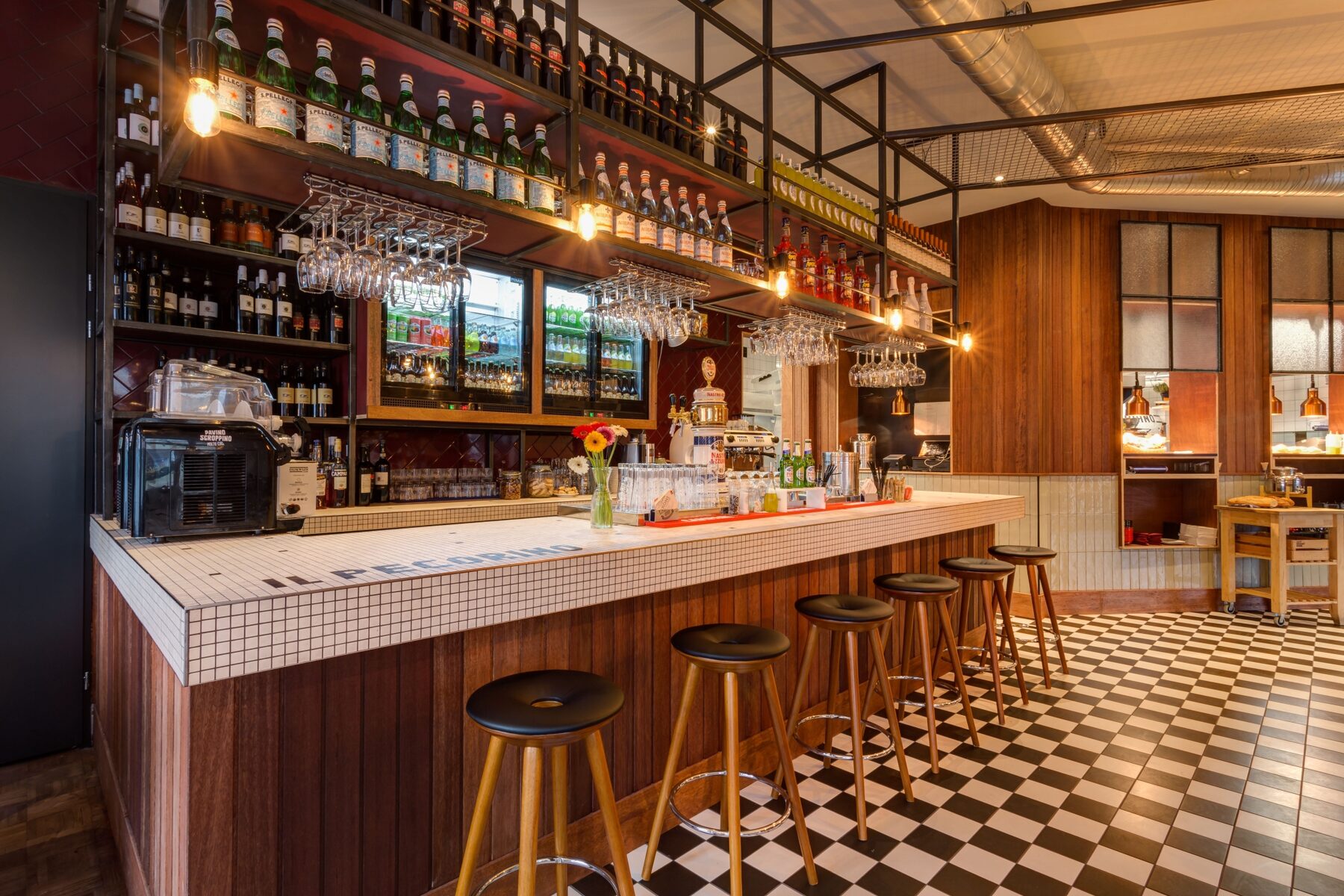 De lange bar met tegels en zwart-wit geblokte vloer